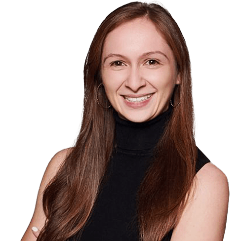 Smiling woman with long brown hair wearing a black sleeveless turtleneck, arms crossed.